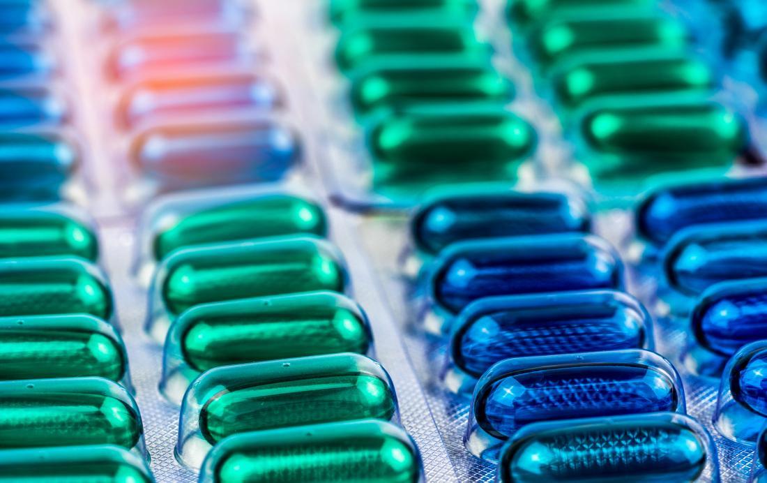 Close-up of green and blue pills in blister packs.
