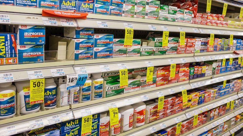 A variety of over-the-counter pain relievers are on display on store shelves.
