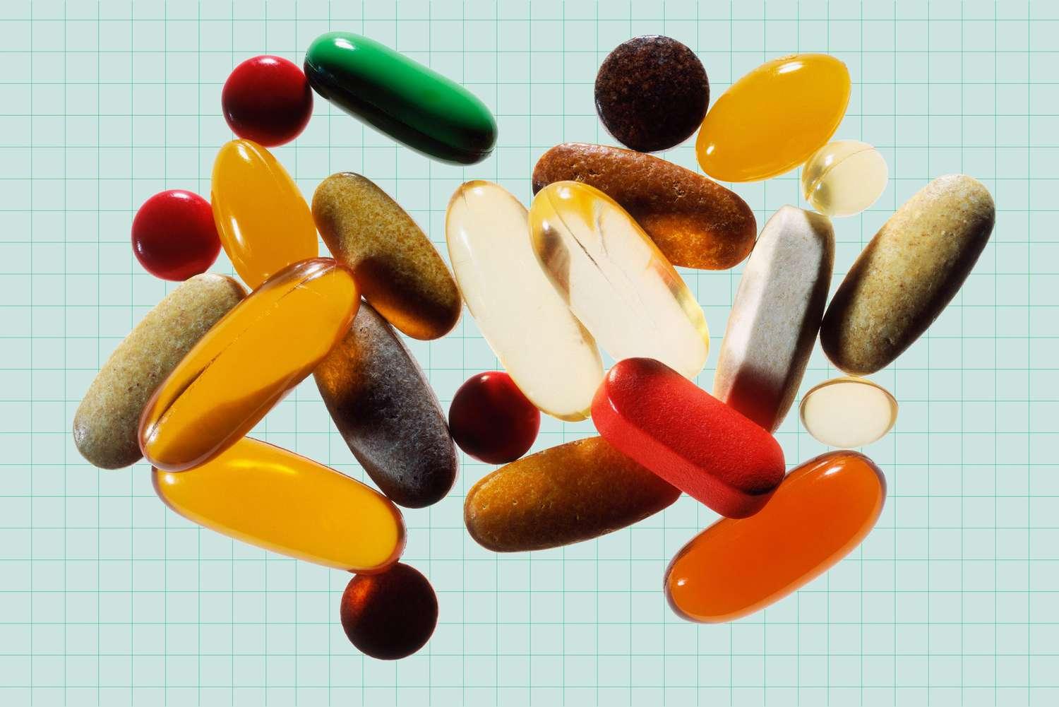 A variety of pills and capsules on a blue-green graph paper background.