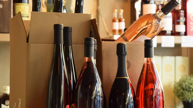 An image of a cardboard box containing six bottles of wine, three bottles of red and three bottles of rose.