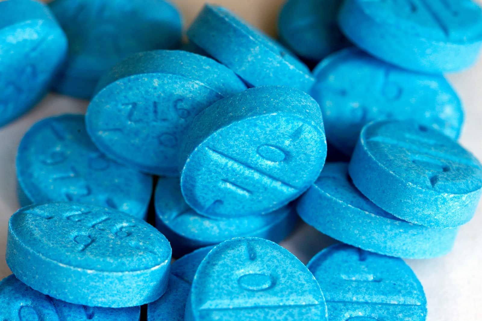 A pile of blue pills with the imprint A4.