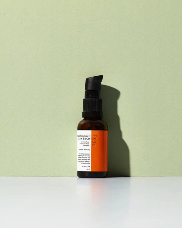 A small brown bottle of Pure Vitamin C 23% Serum with a black lid.