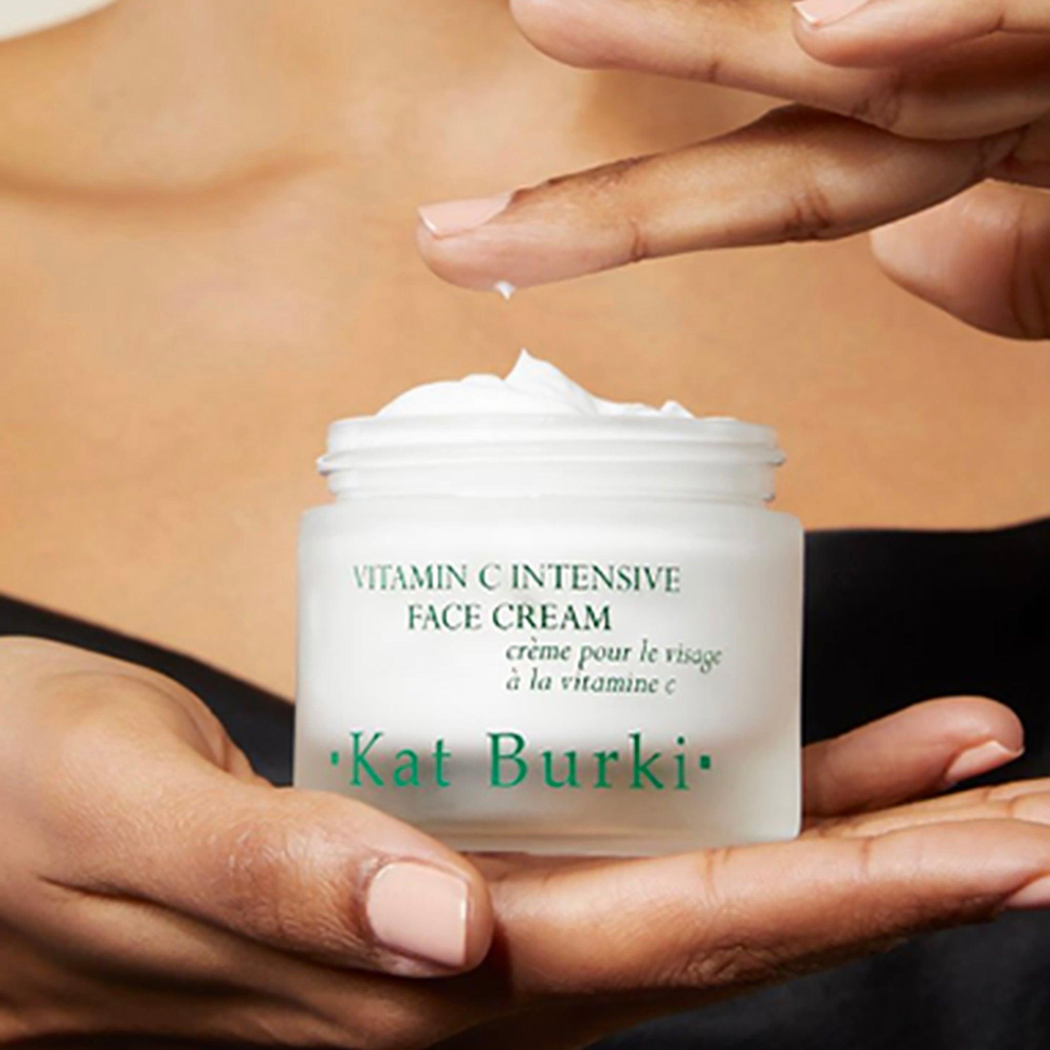A womans hand holding a jar of Vitamin C Intensive Face Cream by Kat Burki.