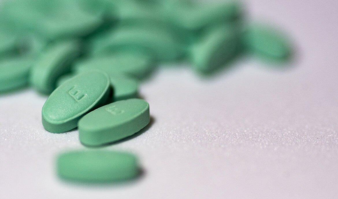 Green pills on a white surface.
