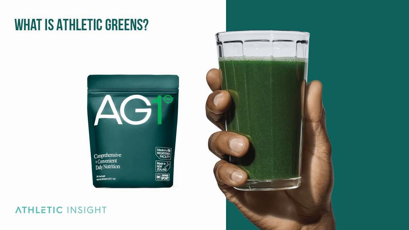A hand holding a clear glass with a green smoothie next to a black and green packet of Athletic Greens powder.