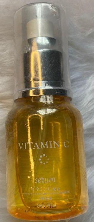A clear bottle of yellow Vitamin C serum with a black lid.