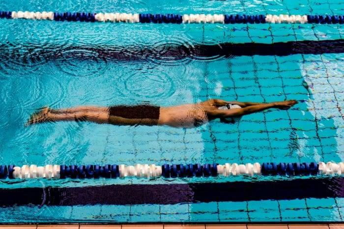 A swimmer glides through the water in a freestyle stroke.