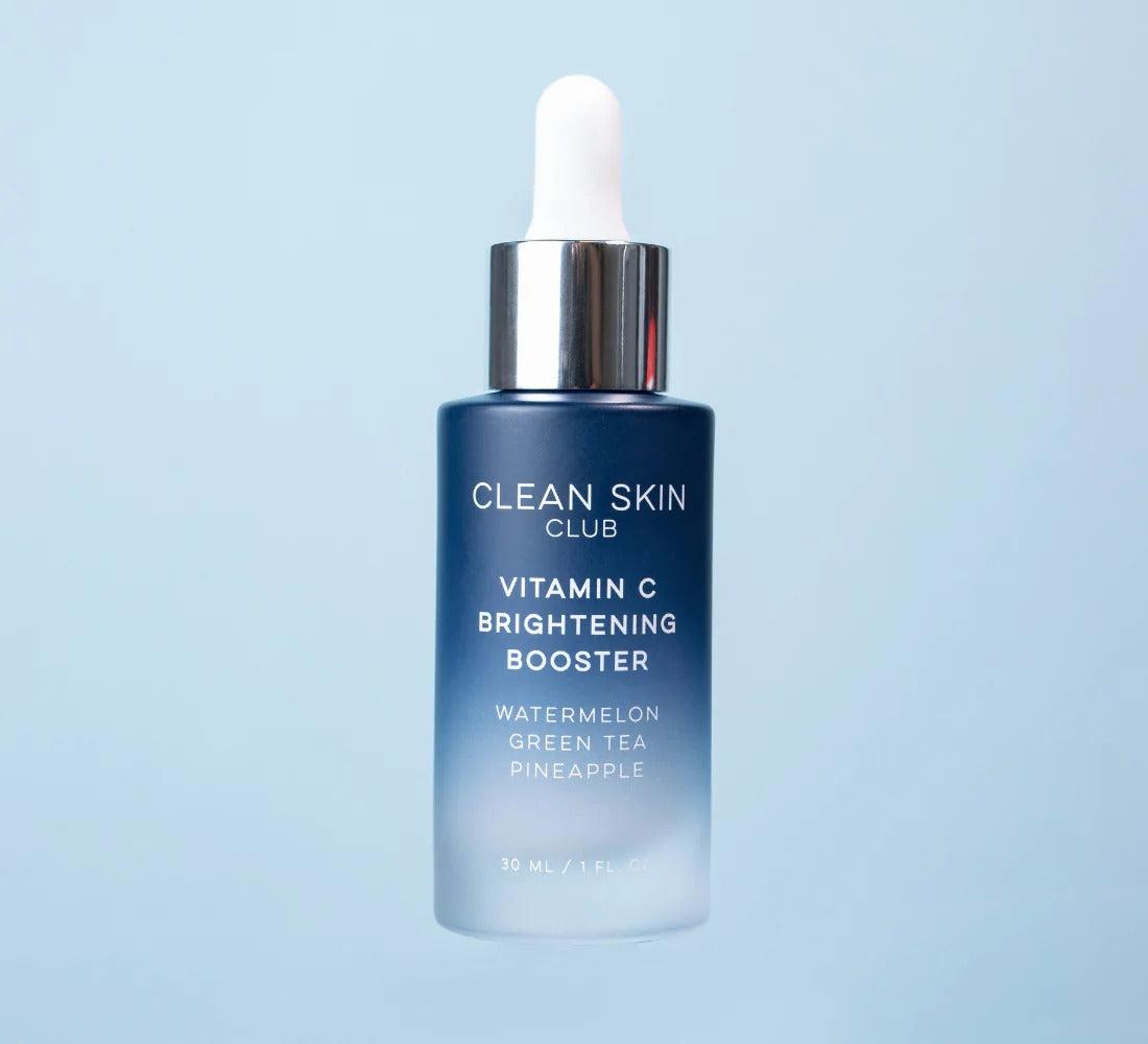 A blue bottle of Clean Skin Club Vitamin C Brightening Booster with watermelon, green tea, and pineapple.