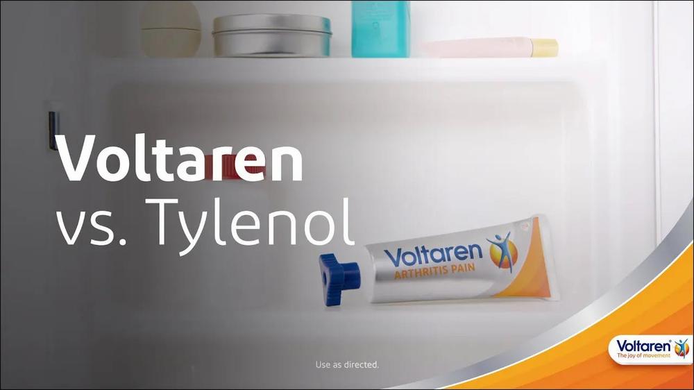 A blue and white tube of Voltaren Arthritis Pain gel is shown on a shelf next to a variety of cosmetics and toiletries.