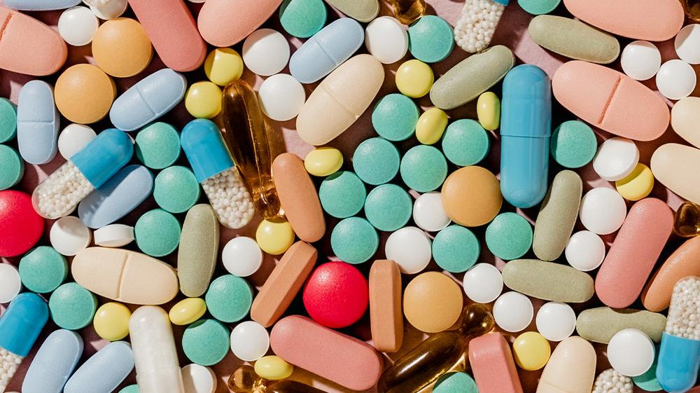 A close up of a pile of colorful pills and capsules.