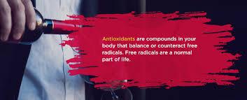 A man in a white shirt is pouring red wine into a glass with the text Antioxidants are compounds in your body that balance or counteract free radicals. Free radicals are a normal part of life.