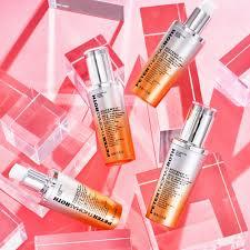Three bottles of Peter Thomas Roth Water Drench Hyaluronic Cloud Serum on a pink and white background.