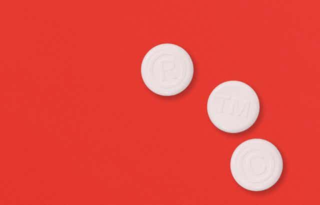 Three white pills on a red background.