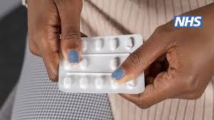 A close up of a womans hands holding a packet of contraceptive pills.