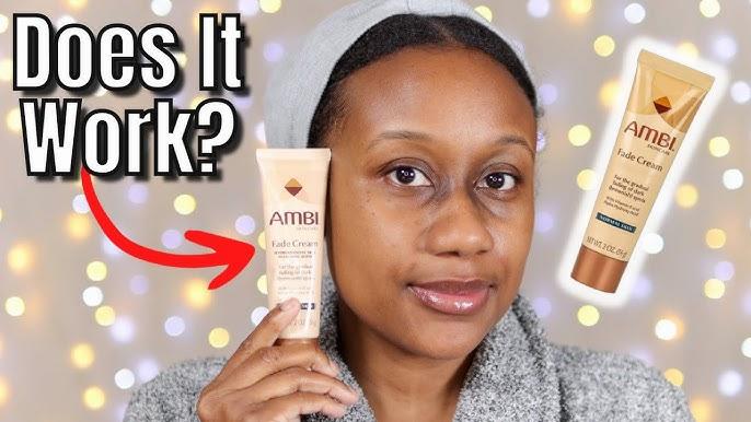 A woman holds a tube of Ambi Fade Cream in front of her face.