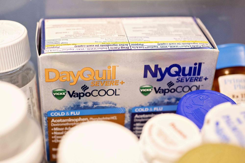 A box of DayQuil Severe and a box of NyQuil Severe, both Vicks VapoCool products, sit on a table with other pill bottles.