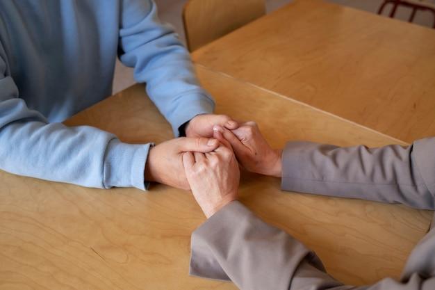 A close up of two people holding hands across a table.
