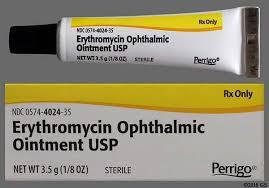 A yellow and white tube of erythromycin ophthalmic ointment, an antibiotic medication used to treat eye infections.
