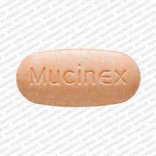 A light brown oval pill with Mucinex imprinted on one side.