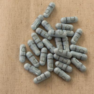 A pile of blue and white pills on a beige cloth.