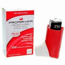 A red and white inhaler for asthma with a black mouthpiece and a red cap, next to a white and red box with the label Proair HFA (albuterol sulfate) Inhalation Aerosol.