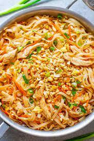 Pad Thai is a popular Thai street food dish made with chicken, rice noodles, eggs, tofu, and crushed peanuts.